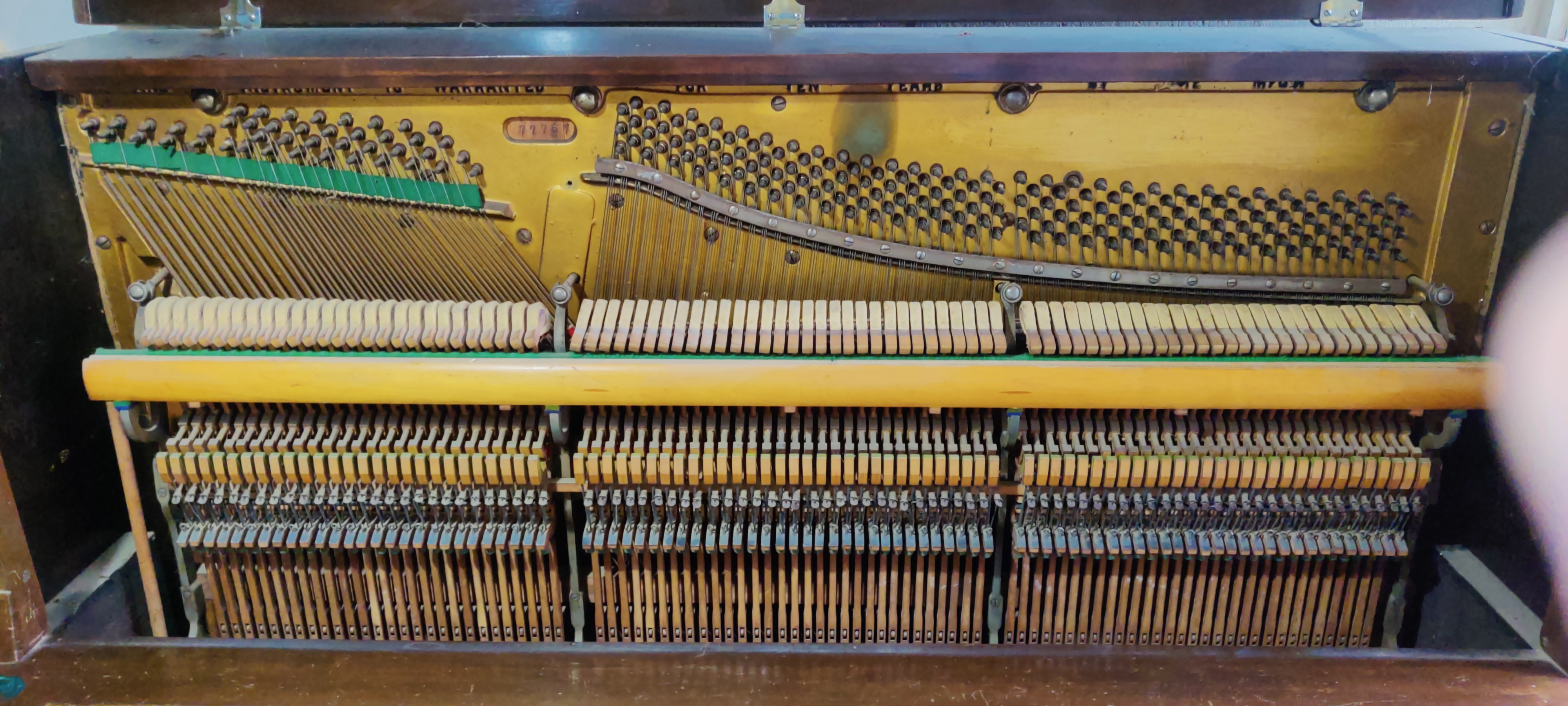 An upright piano being worked on.